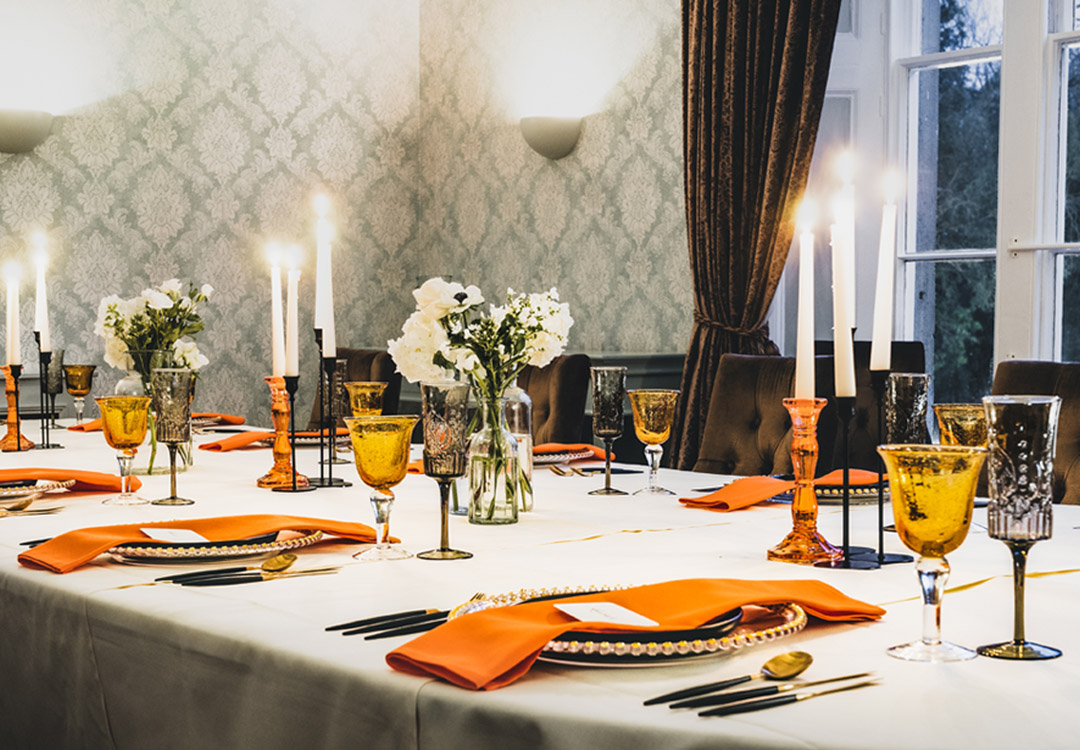 a dining table set with places for dinner in a grand room