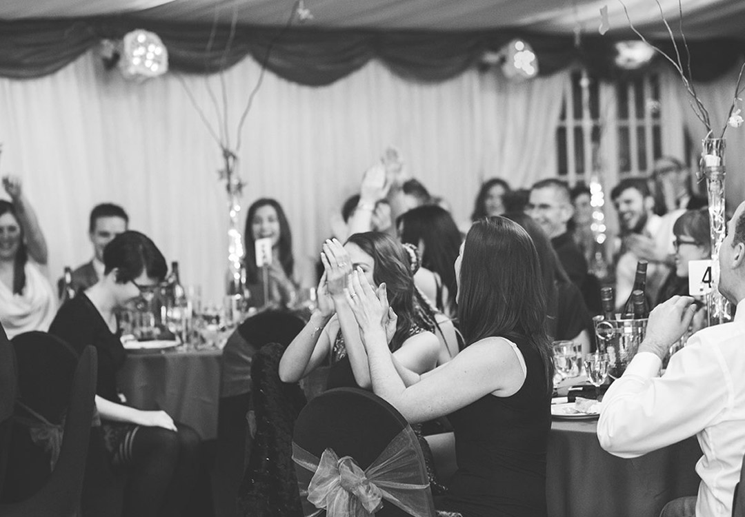 a group of people seated clapping their hands at a festive party